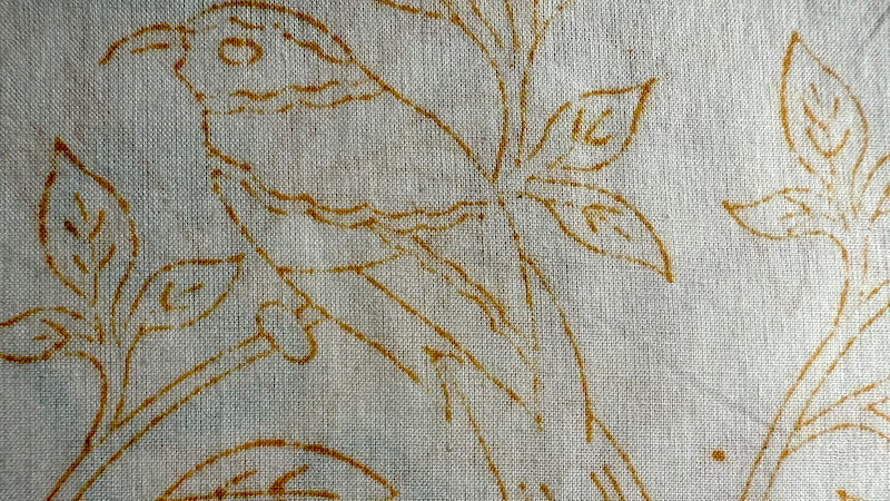 Textile with brown bird and leaf pattern on a light background